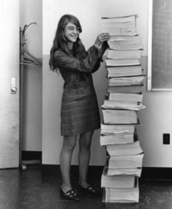 Margaret, in 1969, standing beside the listings of the actual Apollo Guidance Computer source code. Photo courtesy of the MIT Museum.